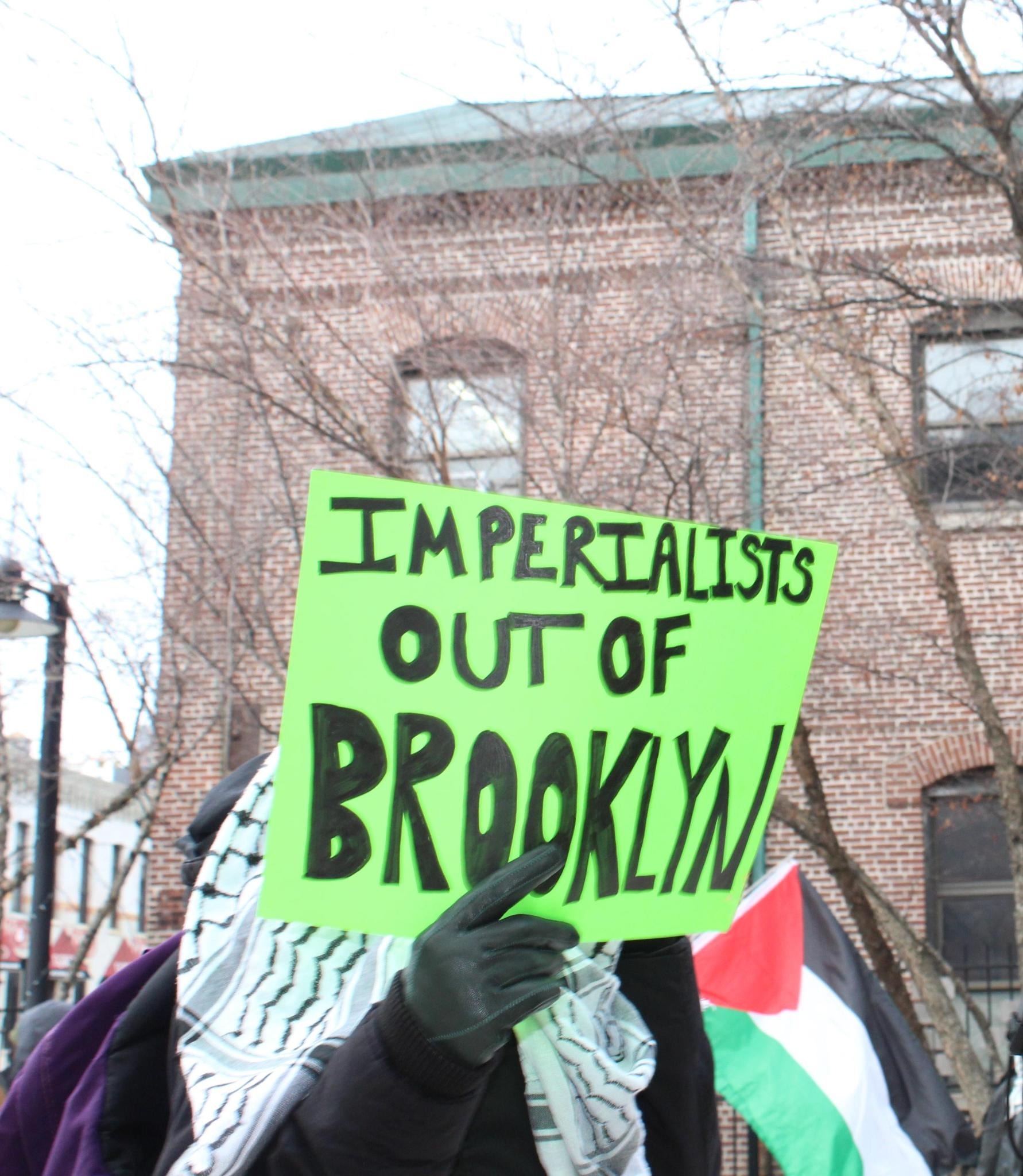 Protester holding 'IMPERIALISTS OUT OF BROOKLYN' sign